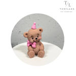 Шоколадна фігурка "Ведмедик коричневий з рожевим бантиком та ковпачком"